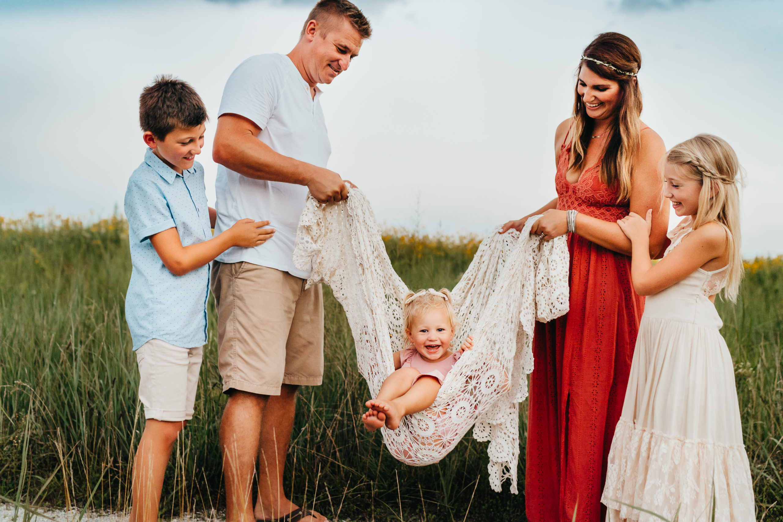 little girl swinging on blanket during family photography session in St. Louis